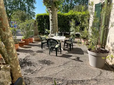 a patio with a table and chairs and plants at Maison de l´amitié Homps in Homps