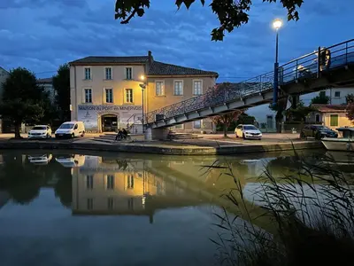 a bridge over a river with cars parked at Maison de l´amitié Homps in Homps