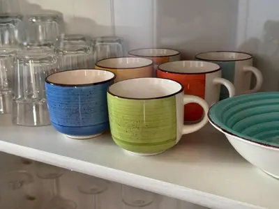 a row of colorful cups sitting on a shelf at Maison de l´amitié Homps in Homps