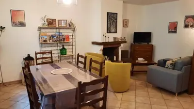 a living room with a table and a couch and a television at A 200 mètres du château : maison de ville in Carcassonne