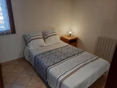 a small bedroom with a bed and a night stand at A 200 mètres du château : maison de ville in Carcassonne