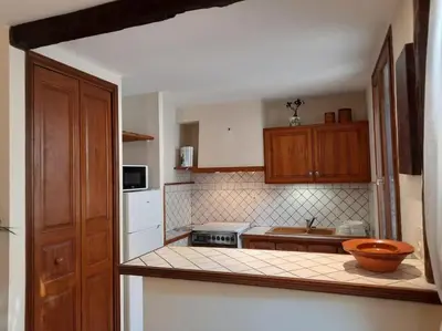 a kitchen with wooden cabinets and a counter top at A 200 mètres du château : maison de ville in Carcassonne
