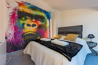 a bedroom with a large painting on the wall at Solstice T2 Hypercentre SmartTV Wifi in Pamiers