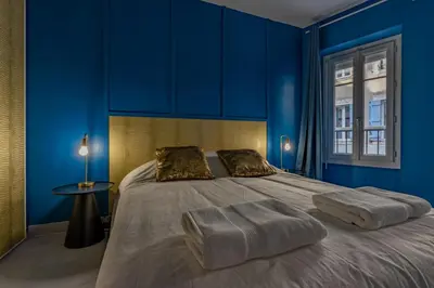 a blue bedroom with a large bed with blue walls at Solstice T2 Hypercentre SmartTV Wifi in Pamiers