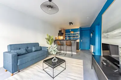 a living room with a blue couch and a table at Solstice T2 Hypercentre SmartTV Wifi in Pamiers