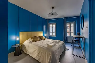 a blue bedroom with a large bed and a stool at Solstice T2 Hypercentre SmartTV Wifi in Pamiers