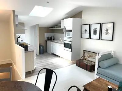 a living room with a blue couch and a kitchen at Cosy Camon Bolt-Hole in Camon