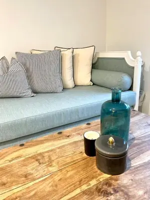 a living room with a couch and a bottle on a wooden floor at Cosy Camon Bolt-Hole in Camon