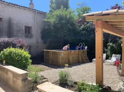 two people sitting in a hot tub in a backyard at Cosy Camon Bolt-Hole in Camon