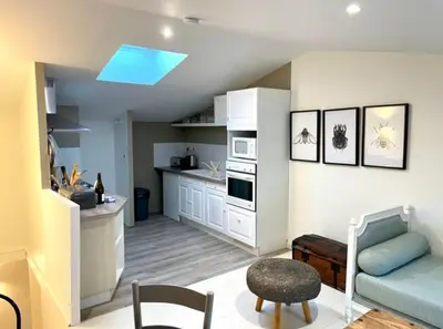 a living room with a blue couch and a kitchen at Cosy Camon Bolt-Hole in Camon