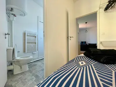 a bedroom with a bed with a blue and white rug at Les appartements d'Arthur - Pont-Neuf in Carcassonne