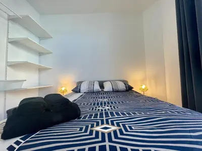 a bedroom with a blue and white bed with two pillows at Les appartements d'Arthur - Pont-Neuf in Carcassonne