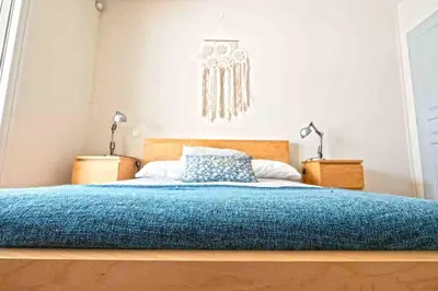 a bedroom with a bed with a blue blanket at Belle villa moderne 3 chambres, jardins terrasse piscine in Durban-Corbières