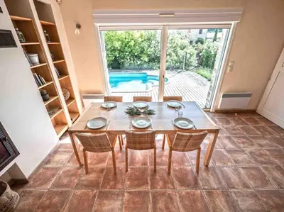 a dining room with a table and chairs and a pool at Belle villa moderne 3 chambres, jardins terrasse piscine in Durban-Corbières