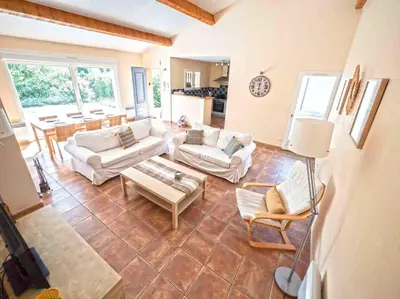 a large living room with couches and a table at Belle villa moderne 3 chambres, jardins terrasse piscine in Durban-Corbières