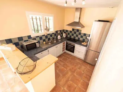 a kitchen with a refrigerator and a counter top at Belle villa moderne 3 chambres, jardins terrasse piscine in Durban-Corbières