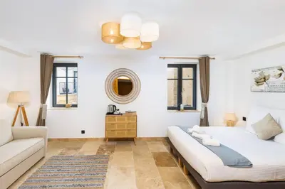 a living room with two beds and a couch at Longue Vie Au Roi - Vue Enchanteresse in Carcassonne