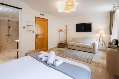 a bedroom with a white bed and a tv at Longue Vie Au Roi - Vue Enchanteresse in Carcassonne