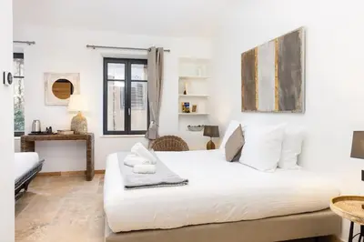 a white bedroom with a large bed and a table at Longue Vie Au Roi - Vue Enchanteresse in Carcassonne