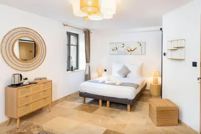 a bedroom with a bed and a dresser and a mirror at Longue Vie Au Roi - Vue Enchanteresse in Carcassonne