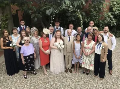 a group of people posing for a picture at a wedding at Le Manoir d'Amiel a secret 16 bedroom garden oasis for groups up to 30 in Villegailhenc
