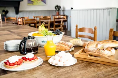 a table with plates of food and a bowl of fruit at Le Manoir d'Amiel a secret 16 bedroom garden oasis for groups up to 30 in Villegailhenc