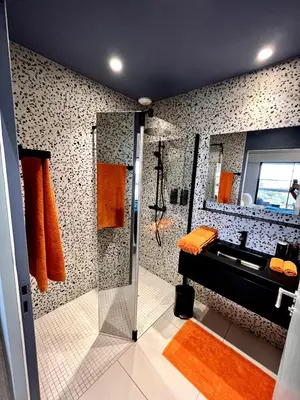 a bathroom with a sink and a shower with orange towels at Suite 28 in Treilles