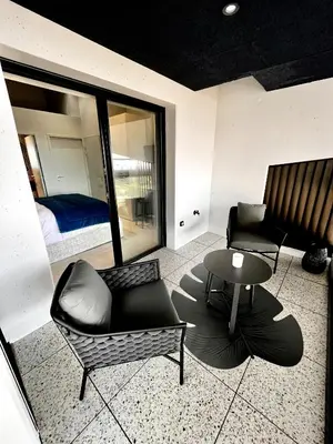 a living room with a couch and a table and a bed at Suite 28 in Treilles
