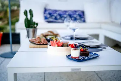a table with two plates of food and a glass of wine at Suite 28 in Treilles