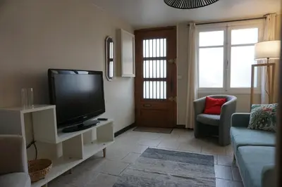 a living room with a flat screen tv and a couch at Le 100 in Carcassonne