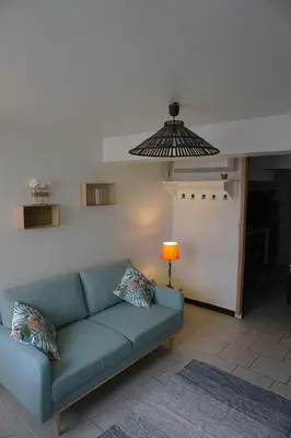 a living room with a blue couch and a lamp at Le 100 in Carcassonne
