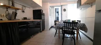 a kitchen with a table and chairs in a room at Le 100 in Carcassonne