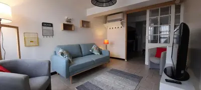 a living room with a blue couch and a bed at Le 100 in Carcassonne