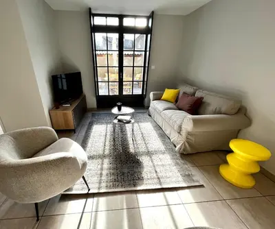 a living room with a couch and a tv at Les Demoiselles de la Tour ! in Carcassonne