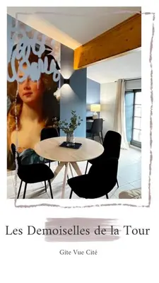 a table and chairs in a living room with a picture of a woman at Les Demoiselles de la Tour ! in Carcassonne