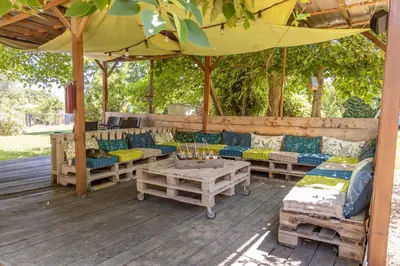 a picnic table in a yard with a playground at Le Mas Rose in Villeneuve-lès-Montréal