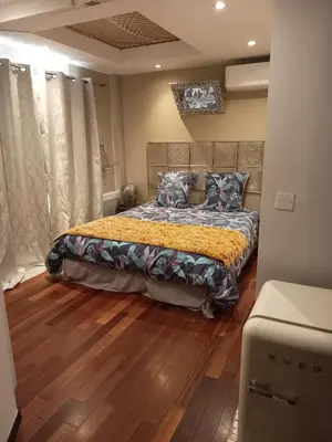 a bedroom with a bed with a yellow blanket at Le Mas Rose in Villeneuve-lès-Montréal