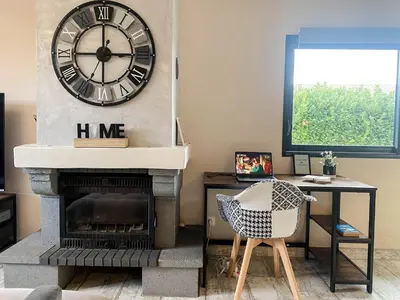 a living room with a fireplace with a clock on the wall at Carcalove - Pool, Billard & Jacuzzi - 10pax in Fontiès-dʼAude