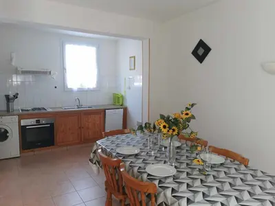 a kitchen with a table with plates and flowers on it at Rouvenac in Trilla