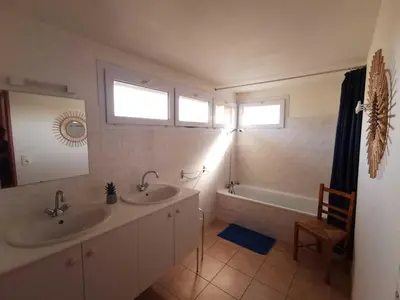 a bathroom with two sinks and a tub and two windows at Rouvenac in Trilla
