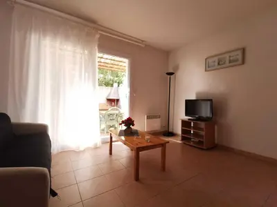 a living room with a couch and a table and a tv at Rouvenac in Trilla