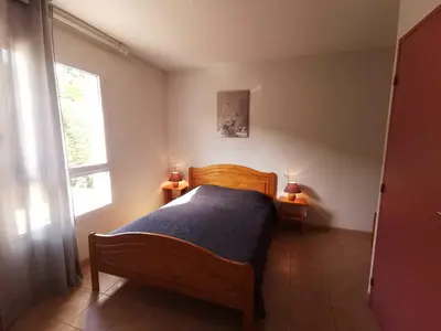a bedroom with a wooden bed and a window at Rouvenac in Trilla