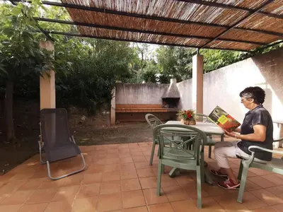 a person sitting at a table under a pergola at Lou soula in Trilla