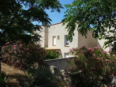 a house seen through some trees and flowers at Lou soula in Trilla