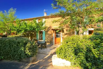 a stone house with a bench in front of it at Domaine du coude in Saint-André-de-Roquelongue
