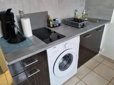 a kitchen with a washing machine and a sink at La cabane bleue à Narbonne in Narbonne