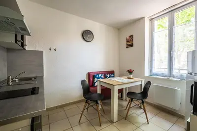 a kitchen with a table and chairs in a kitchen at La cabane bleue à Narbonne in Narbonne