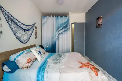 a bedroom with a bed with a net on the wall at La cabane bleue à Narbonne in Narbonne