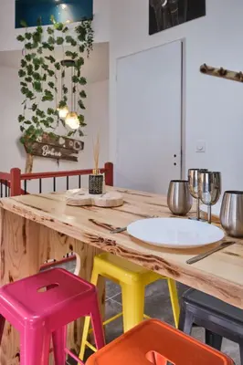 a kitchen with a wooden table with colorful stools at Place Carnot - studio tout équipé avec jacuzzi proche toutes commodités in Carcassonne