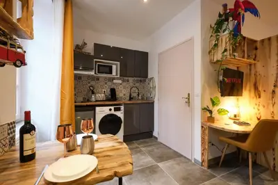 a small kitchen with a table and a kitchen with a tablektop at Place Carnot - studio tout équipé avec jacuzzi proche toutes commodités in Carcassonne